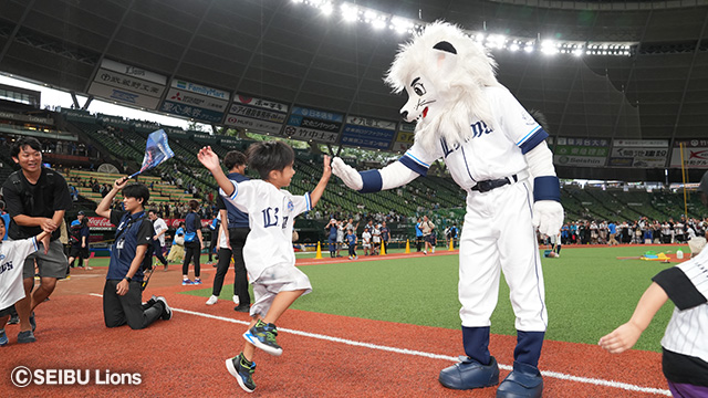 球場でレオくんとハイタッチする少年