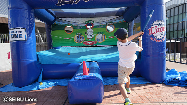 少年が的をめがけてボールを打っている