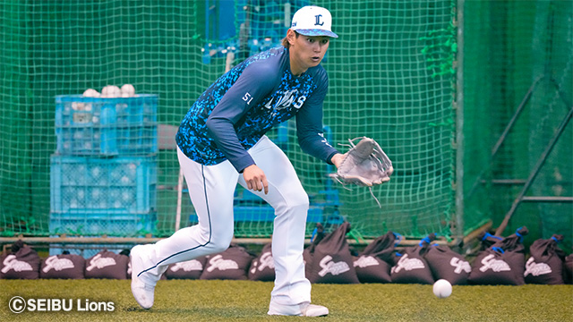 転がってきた球を捉えようとする選手