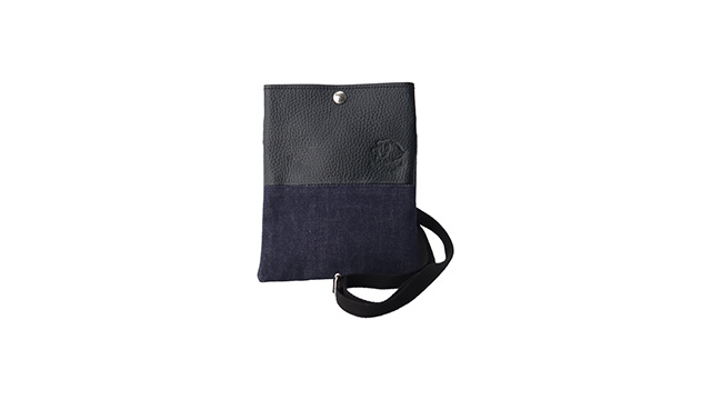 上下で素材が分かれており、上部は本革製、下部はデニム生地でできたショルダーバック。ボタンがついており、上部の本革製の部分の右下にライオンズのロゴが入っている。色は本革製部分が黒、デニム部分が紺色